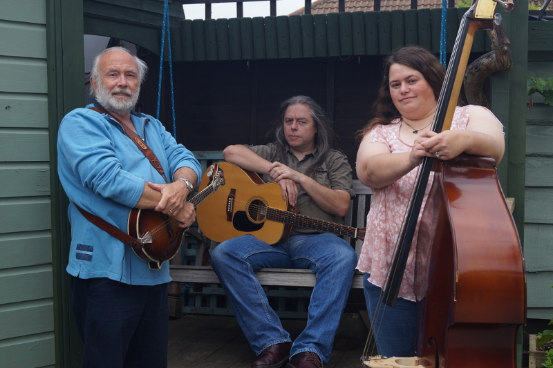 Photograph of Wood, Wire and Words, Pat Francis with mandolin, David Rozzell holding OOO-18 acoustic guitar, Clare Rozzell leaning on her double bass.